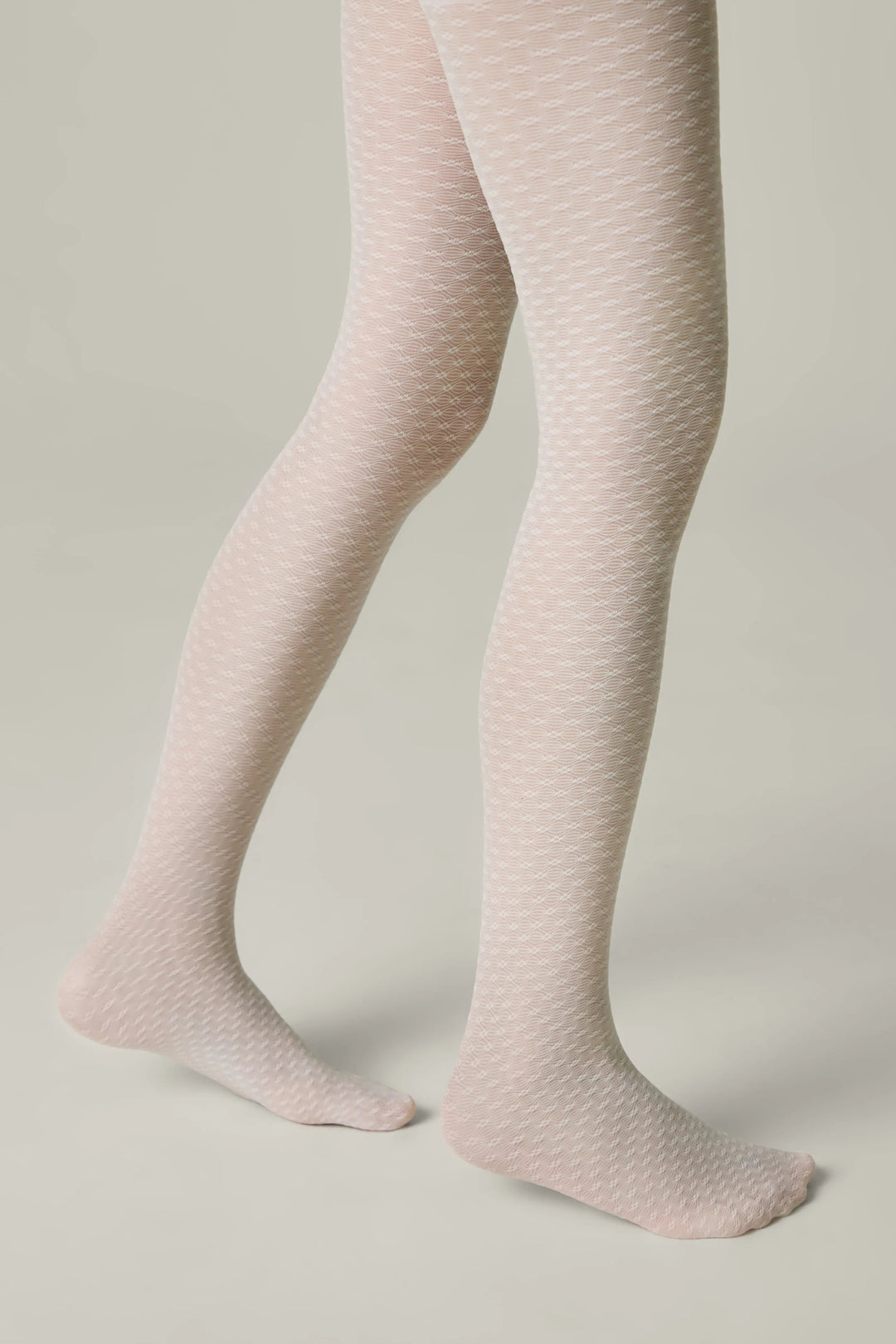Light pink textured tights worn by a person on a neutral background #color_bianco