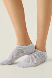 Gray ankle socks worn by a person on a light background #color_light-gray