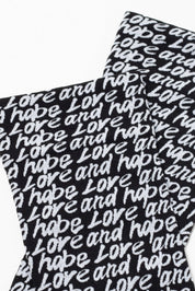 Black socks with 'love and hope' text pattern on a white background #color_nero-bianco