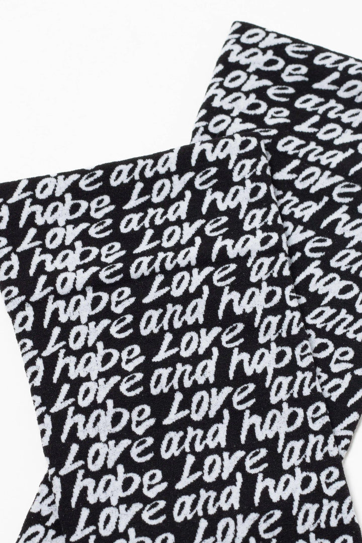 Black socks with 'love and hope' text pattern on a white background #color_nero-bianco