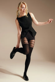 Woman wearing a black outfit with sheer stockings against a beige background #color_nero-black