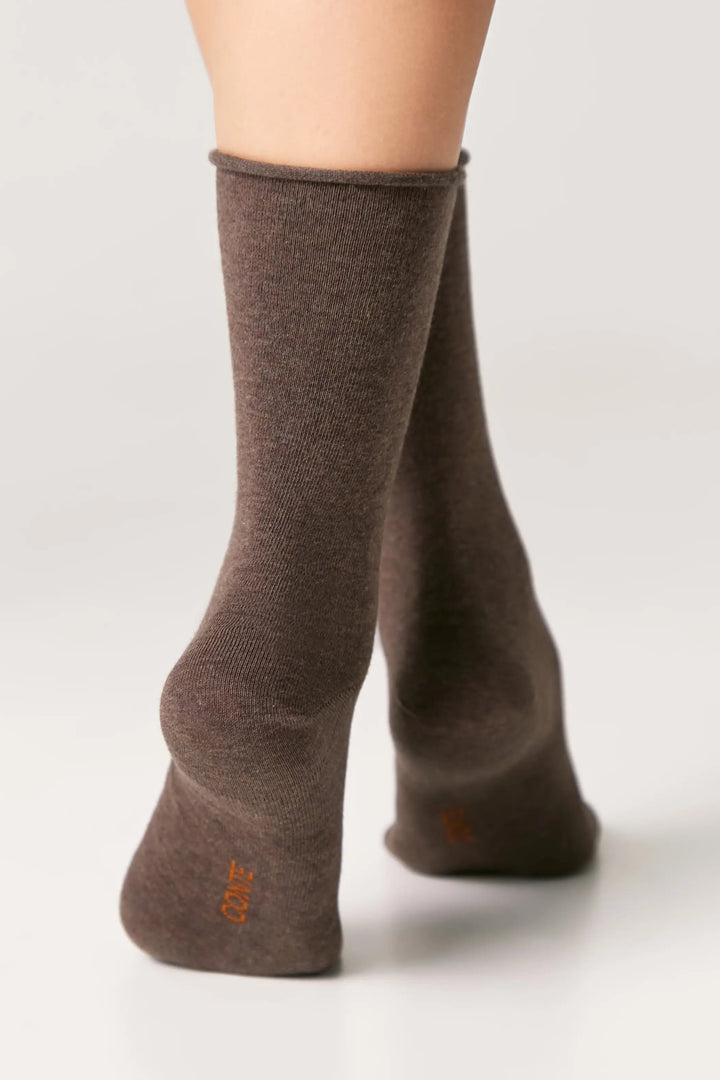 Brown socks worn by a person on a white background #color_brown