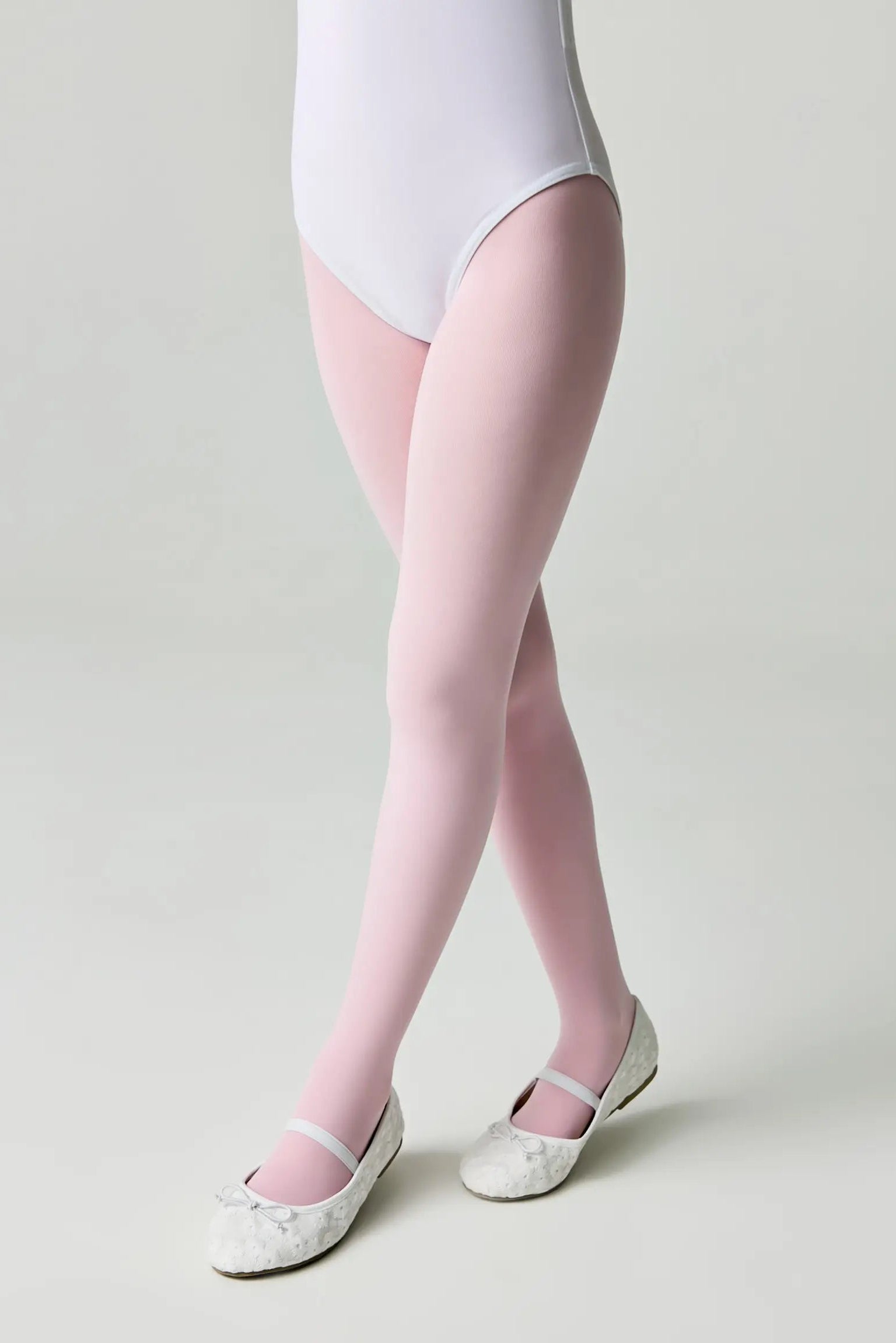 Person wearing pink tights and white shoes on a plain background #color_pink