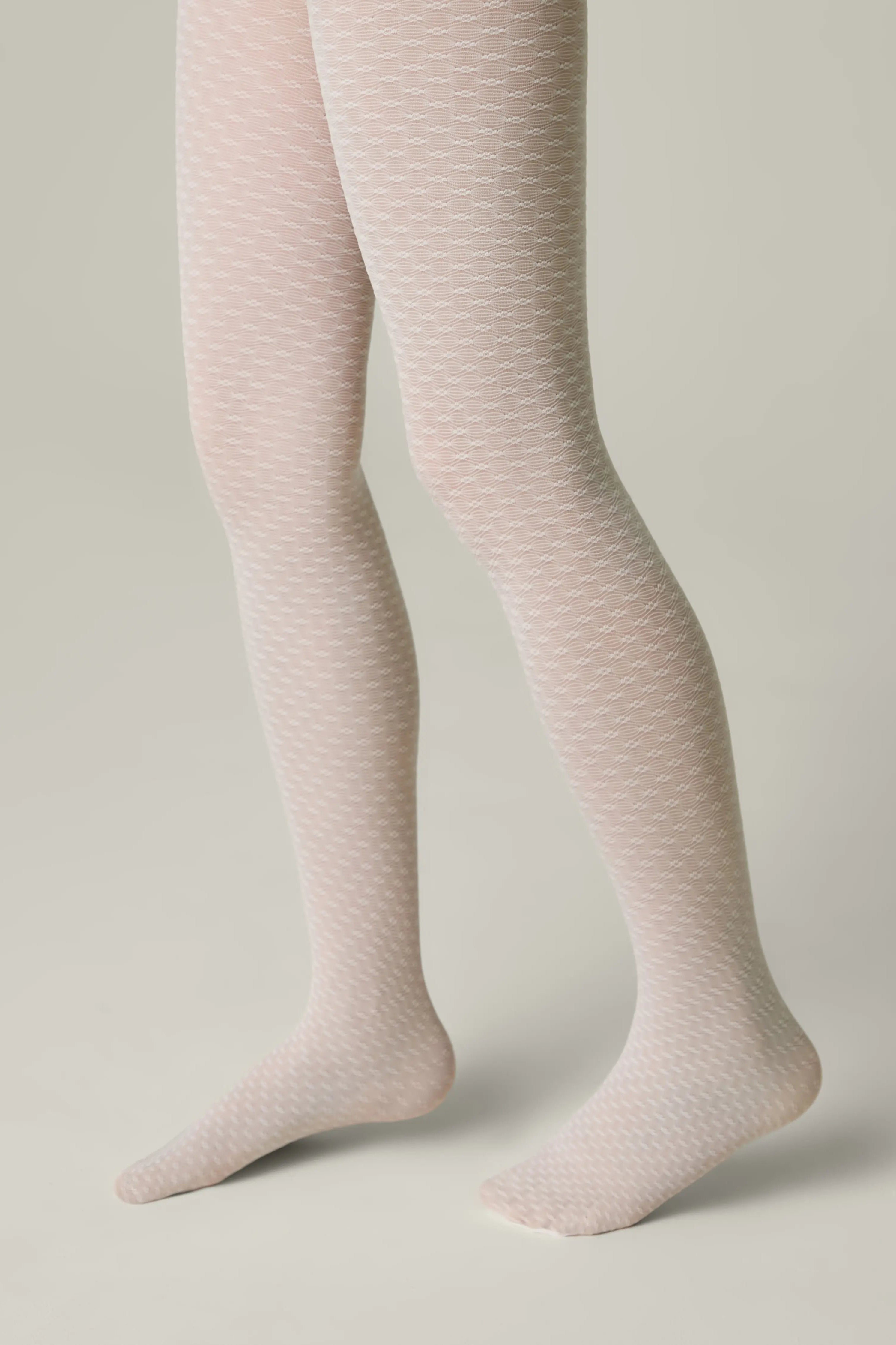 Light pink tights worn by a person on a neutral background #color_bianco