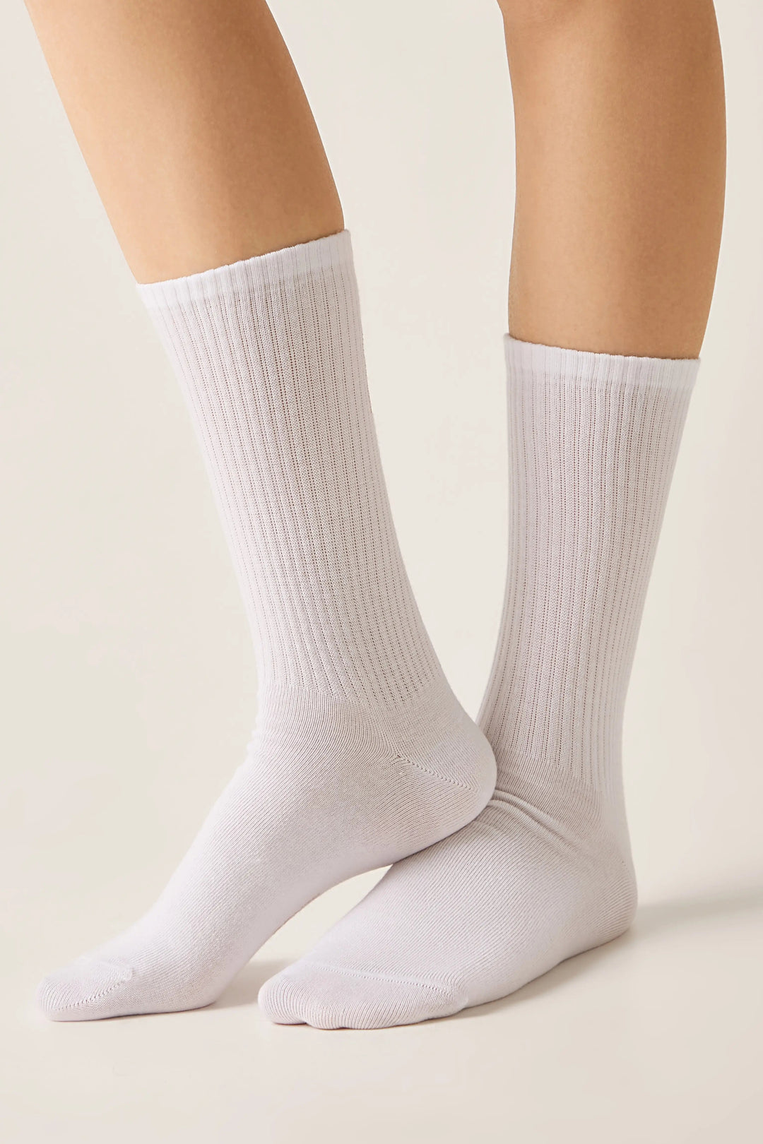 White socks worn by a person on a light beige background