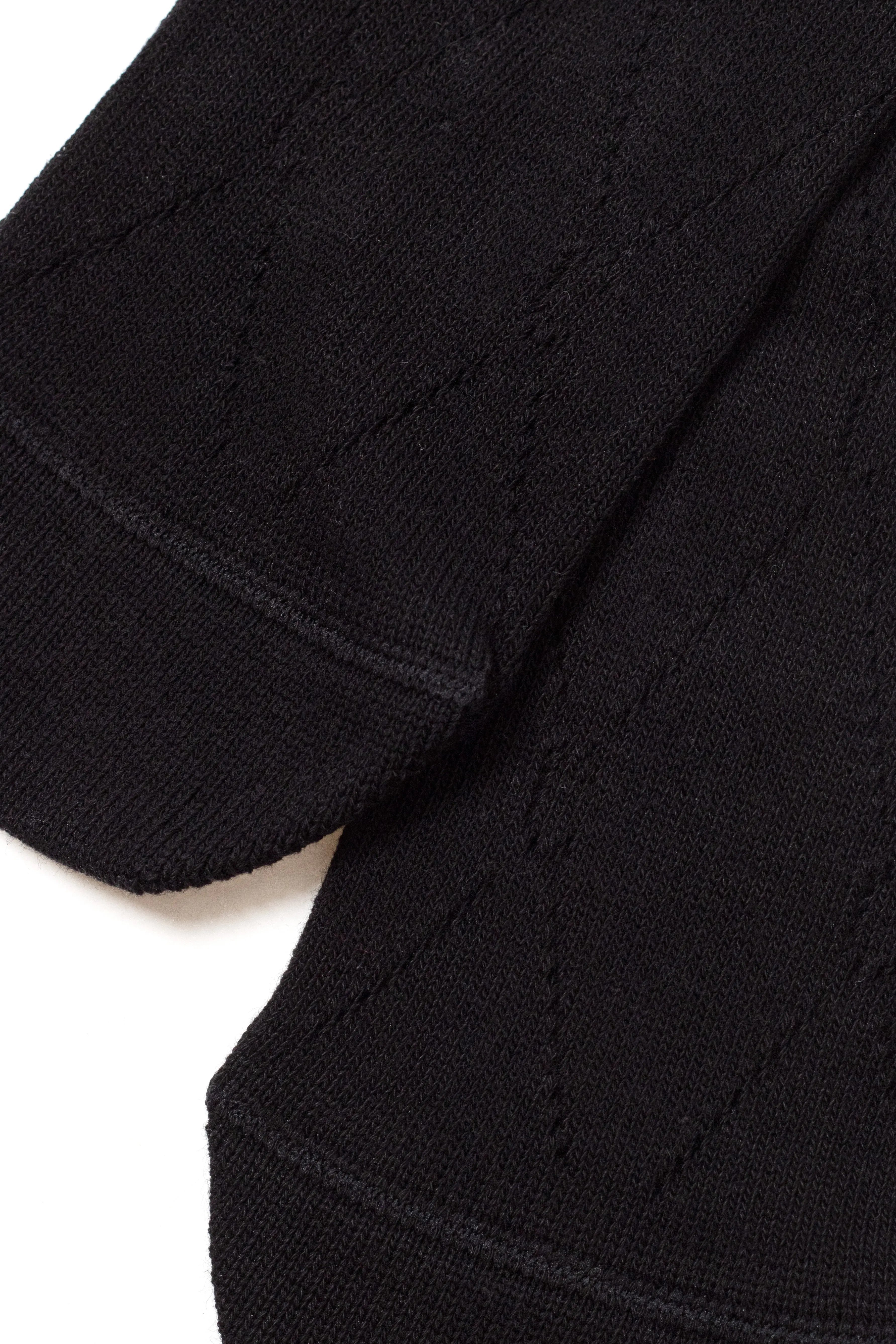 Close-up of a black sweater with a textured pattern on a white background #color_black