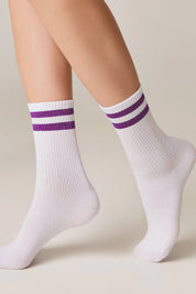 White socks with purple stripes worn by a person on a neutral background #color_lilac
