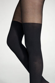 Black knee-high socks worn with sheer black tights on a white background