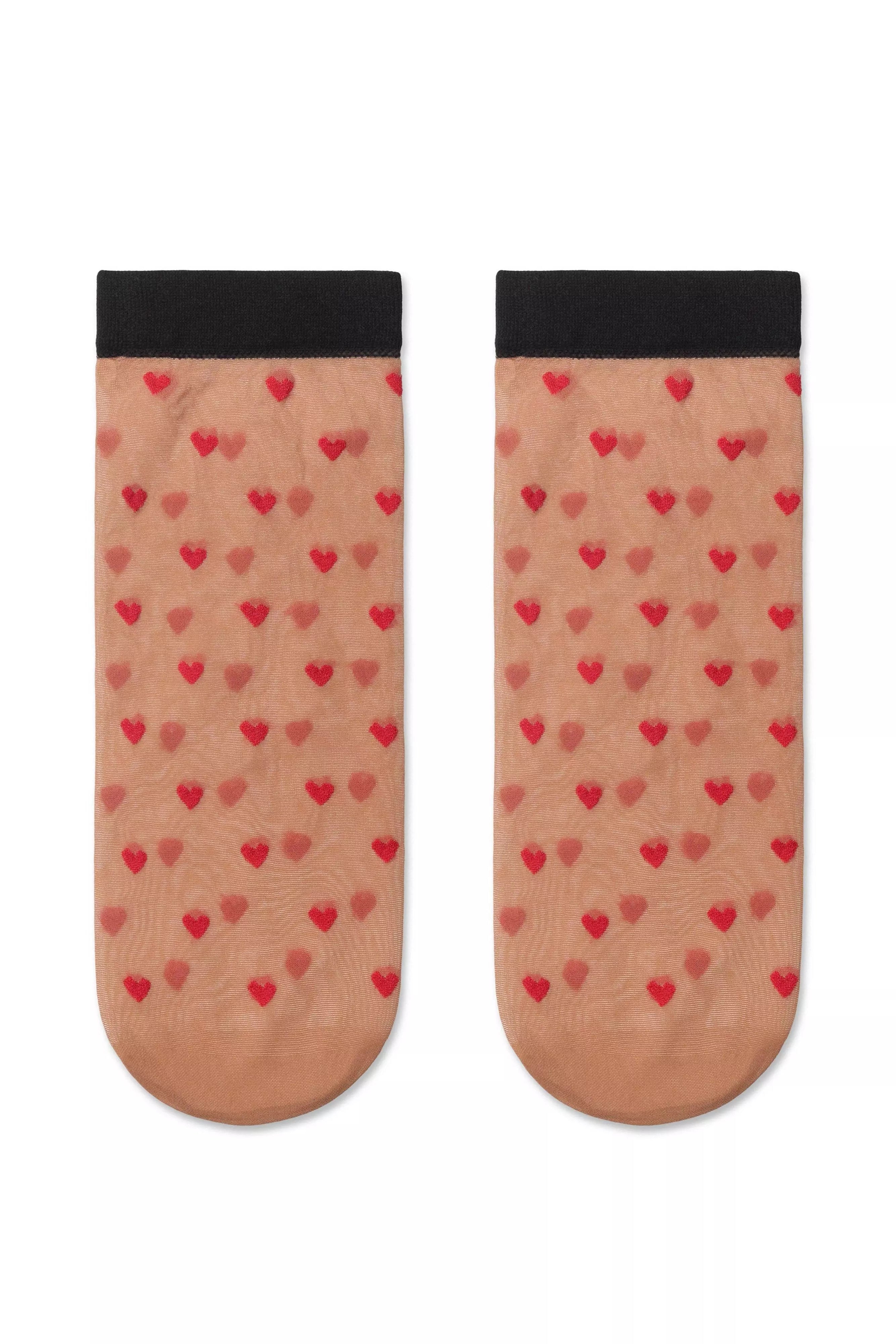 Pair of socks with heart pattern on a white background #color_natural-nude