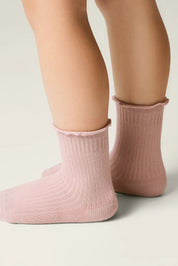 Pink socks worn by a person on a neutral background #color_ash-pink