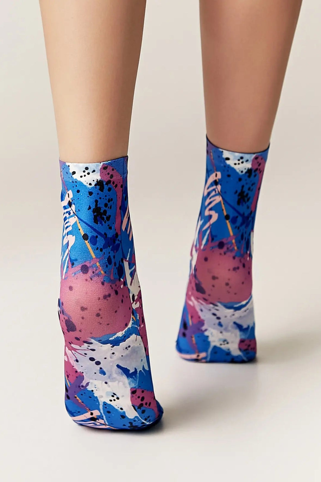 Colorful abstract patterned socks on a plain background