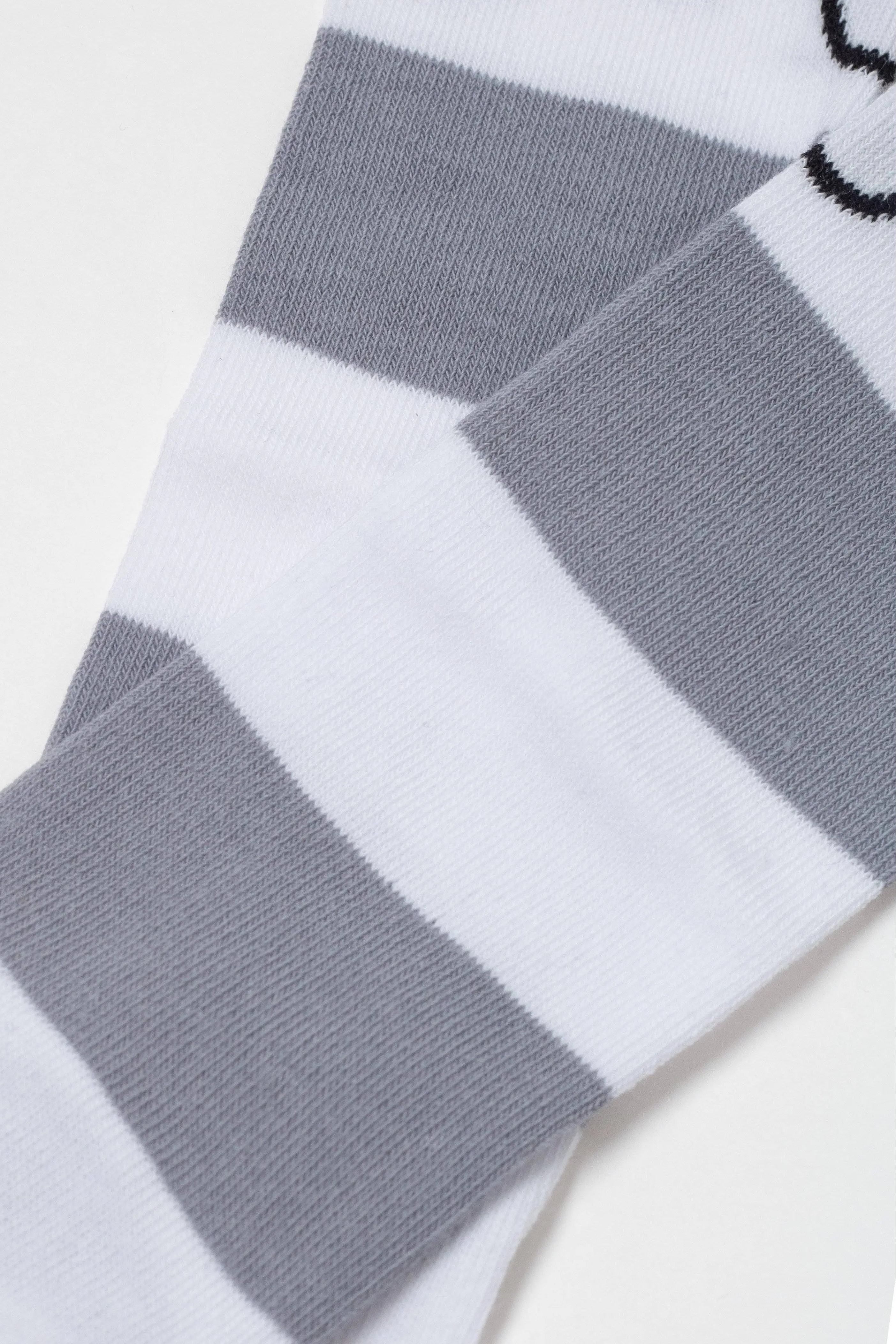 Gray and white striped sock on a light gray background
