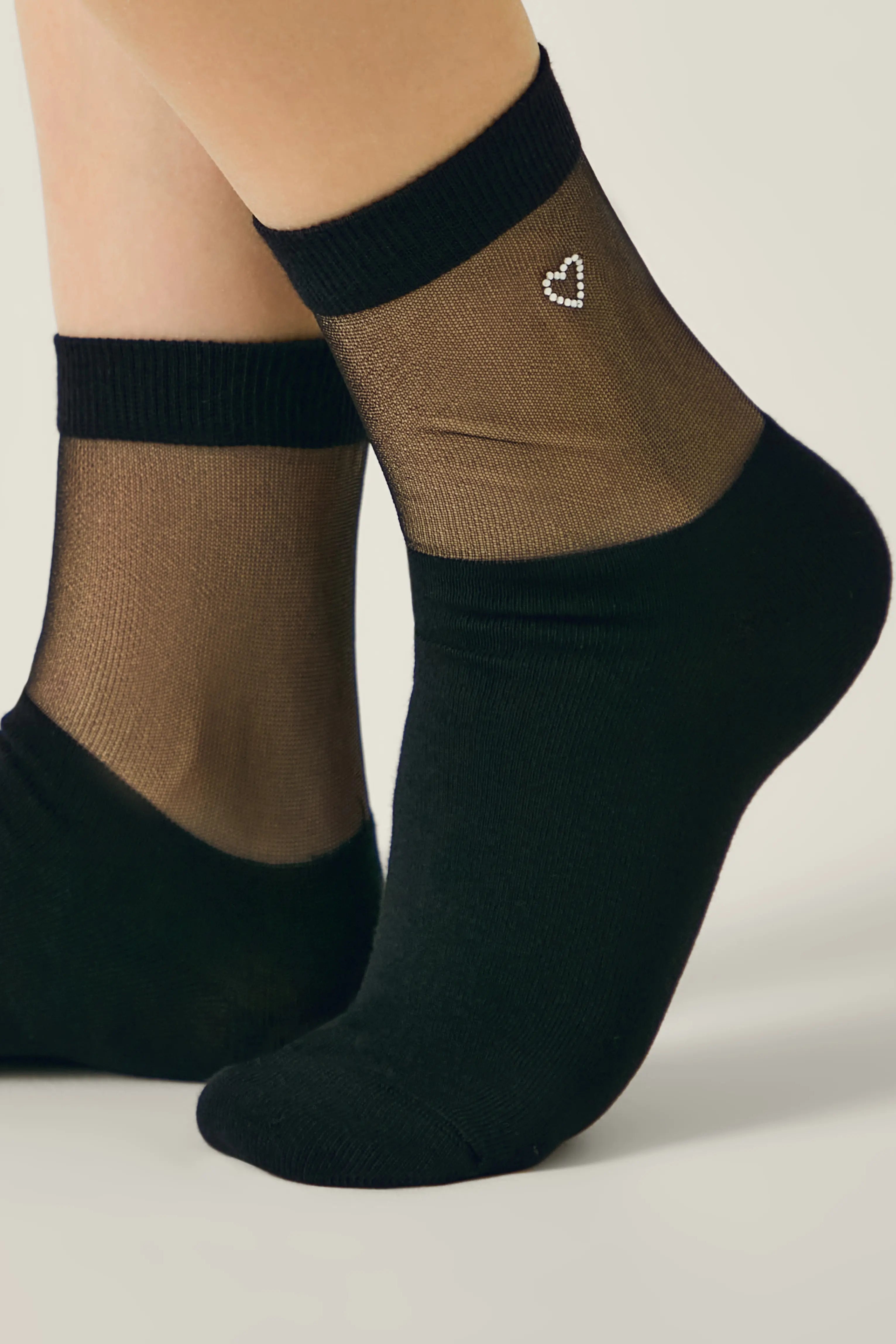 Black sheer socks with a heart design on a neutral background #color_black