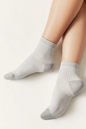 Gray ankle socks worn by a person on a light background #color_gray