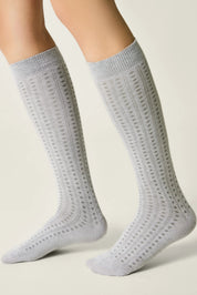 Gray knee-high socks with a subtle pattern worn by a person on a light background #color_light-gray
