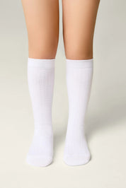 White socks worn by a person on a light gray background #color_white