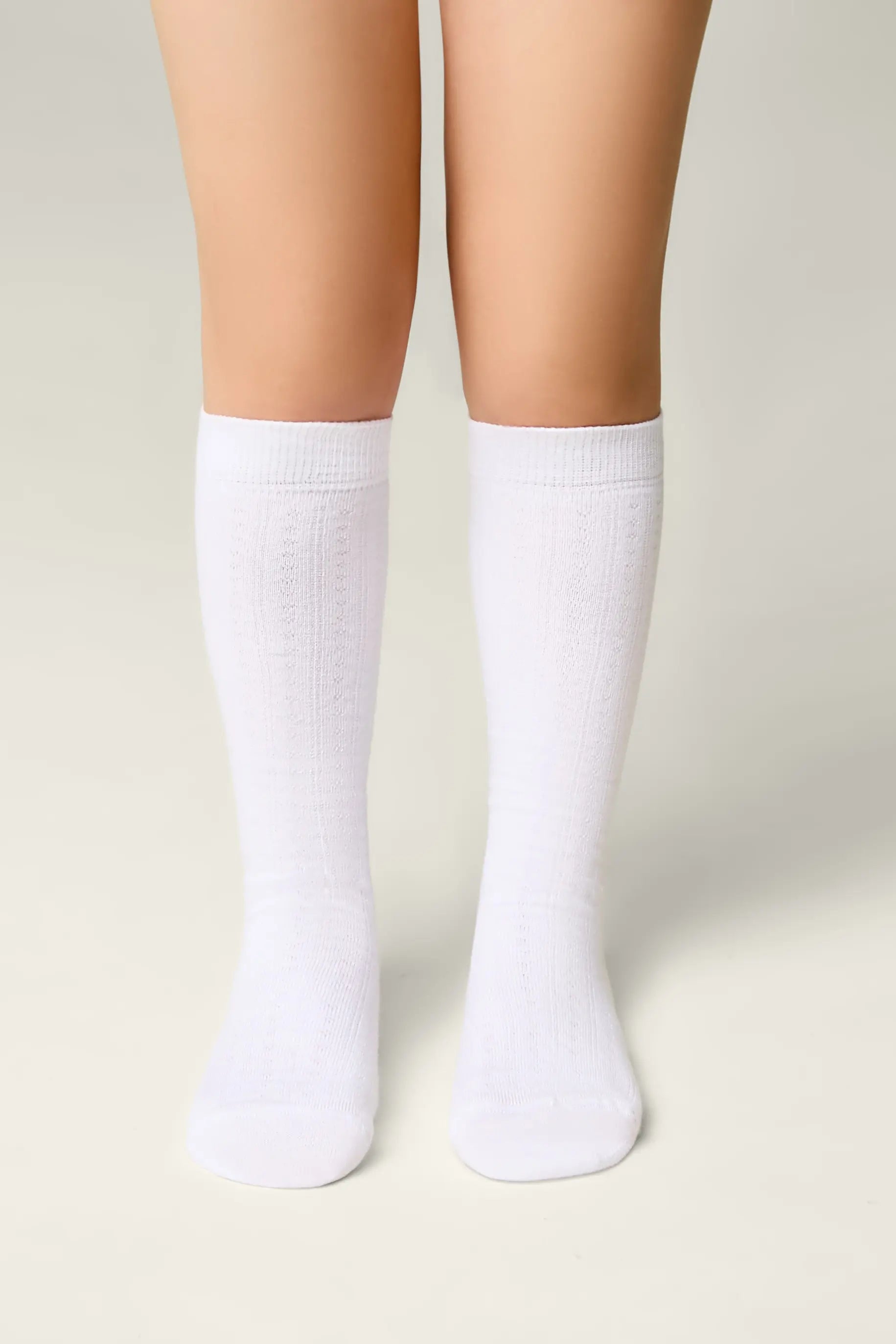 White socks worn by a person on a light gray background #color_white