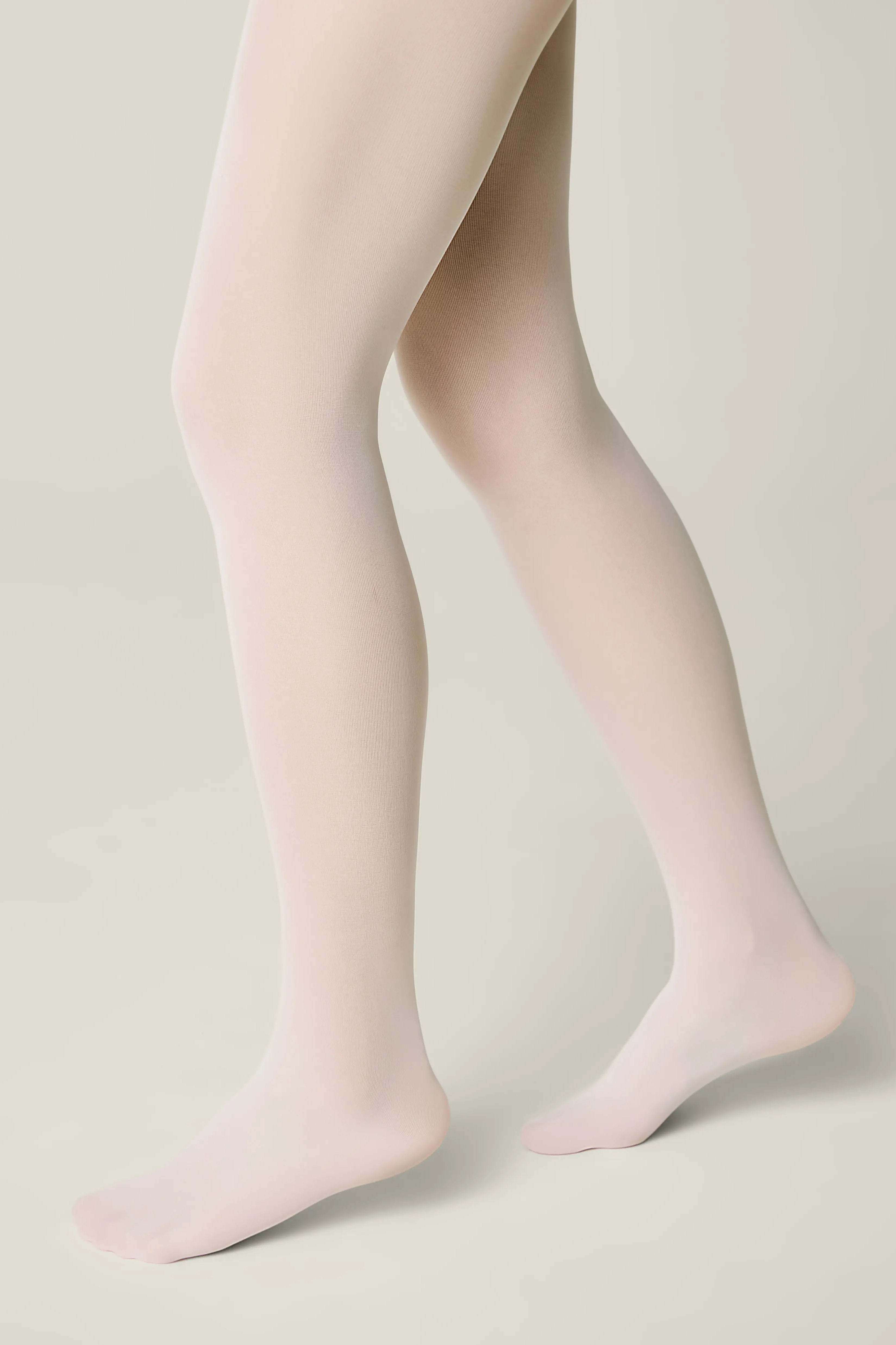 Light pink tights worn by a person on a beige background #color_bianco