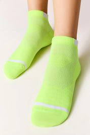 Neon green socks with white stripes worn by a person on a light background #color_lime-green