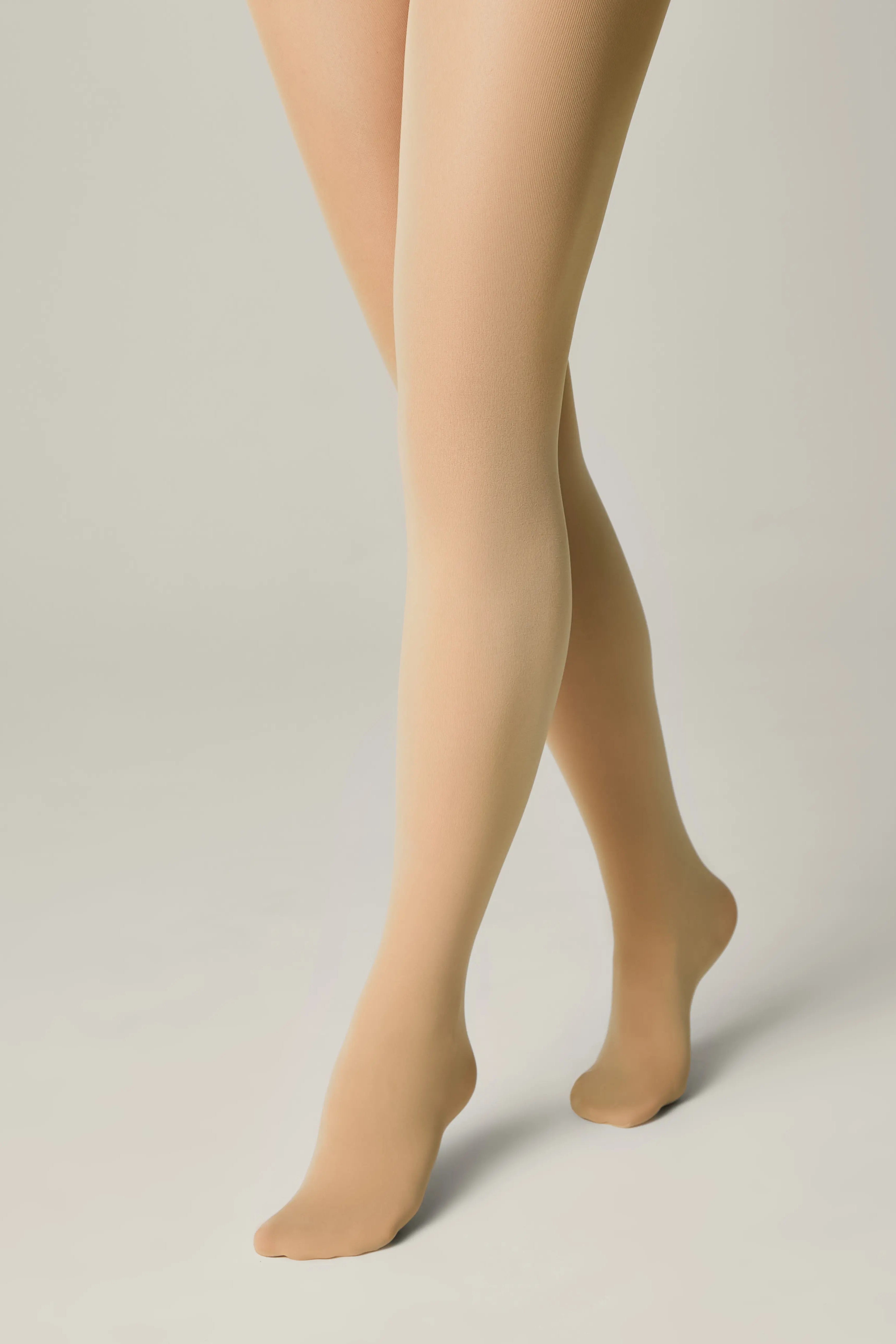 Beige tights worn by a person on a plain background #color_natural-nude