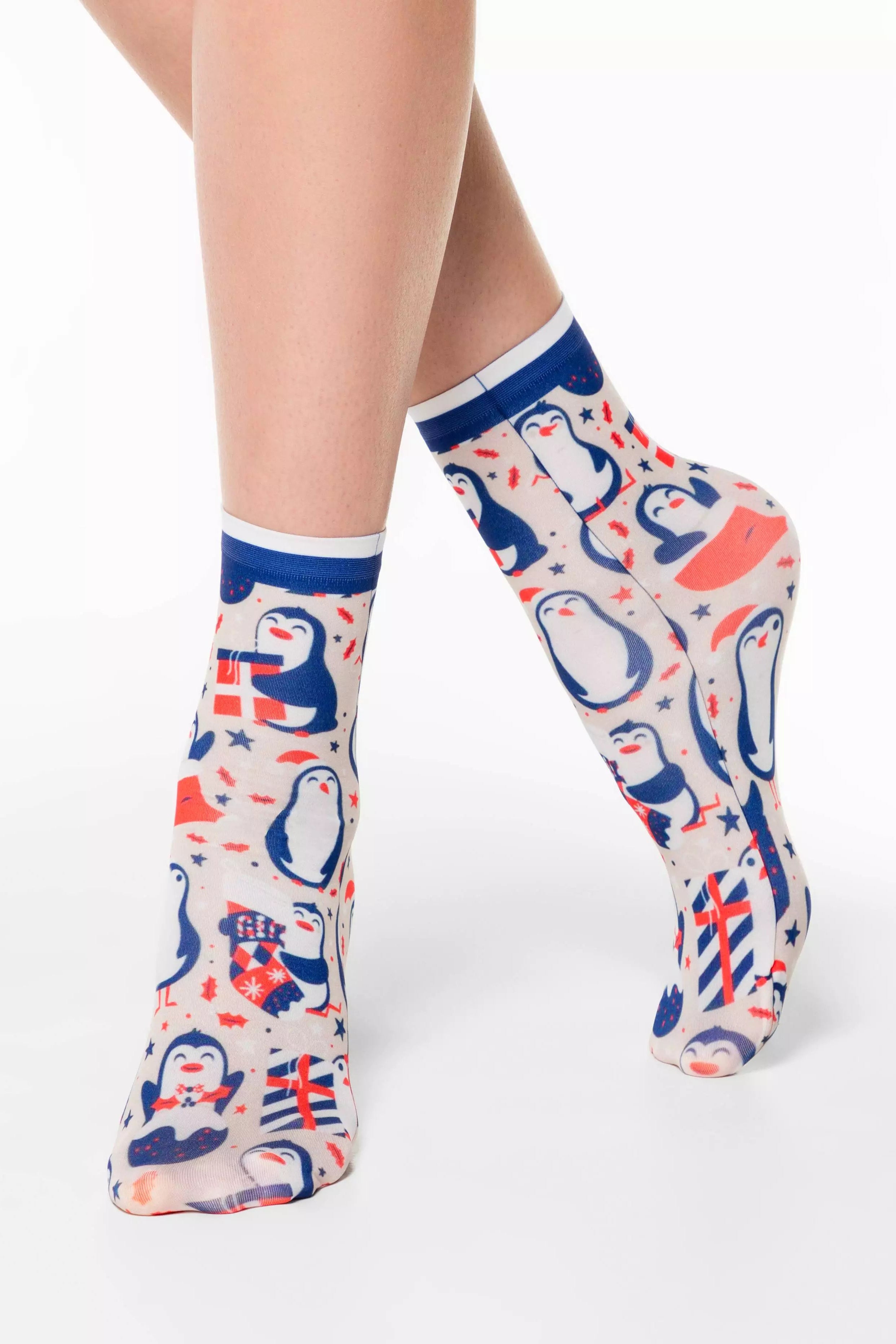 Colorful socks with penguin design worn by a person on a white background